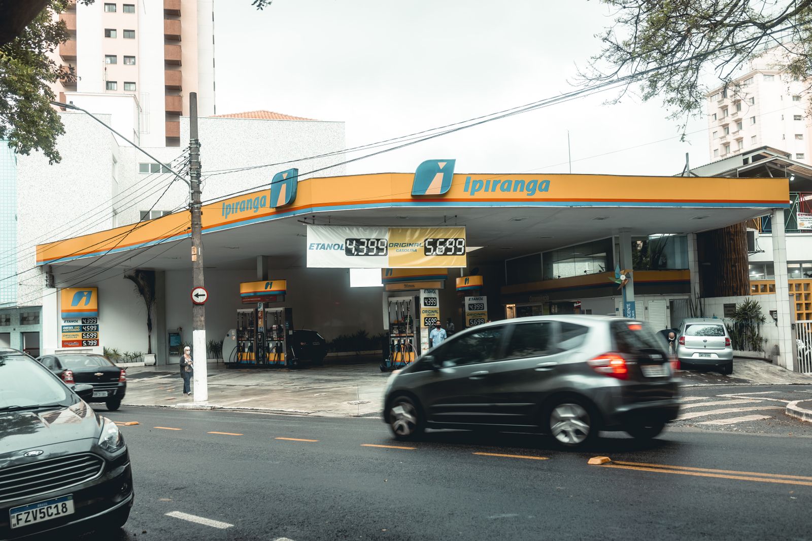 Instalación energética con surtidores de combustible y edificios corporativos al fondo