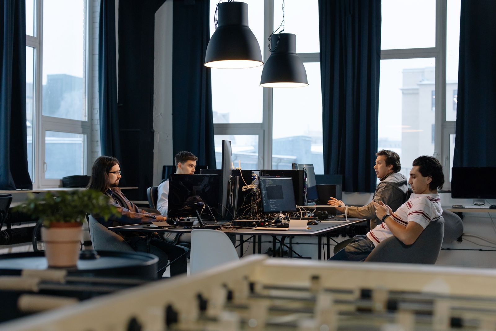 Espacio de trabajo compartido con emprendedores tecnológicos trabajando en computadoras portátiles