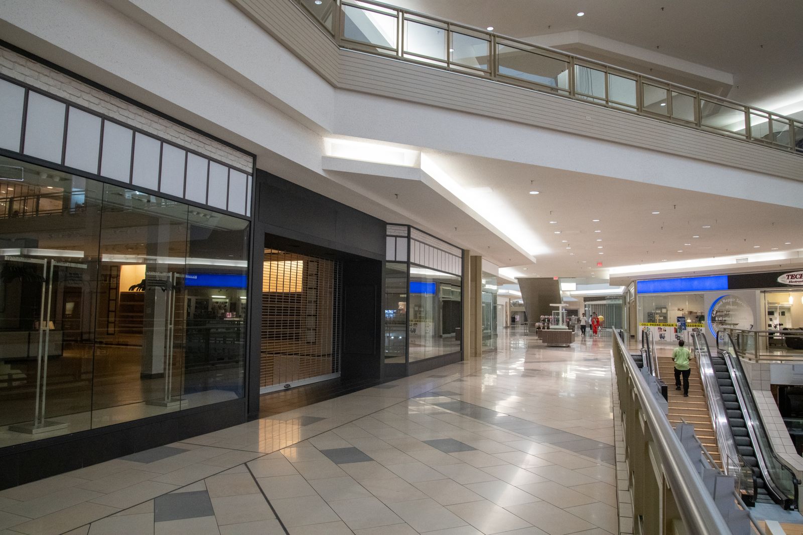 Pasillo iluminado de un centro comercial moderno con vitrinas de tiendas