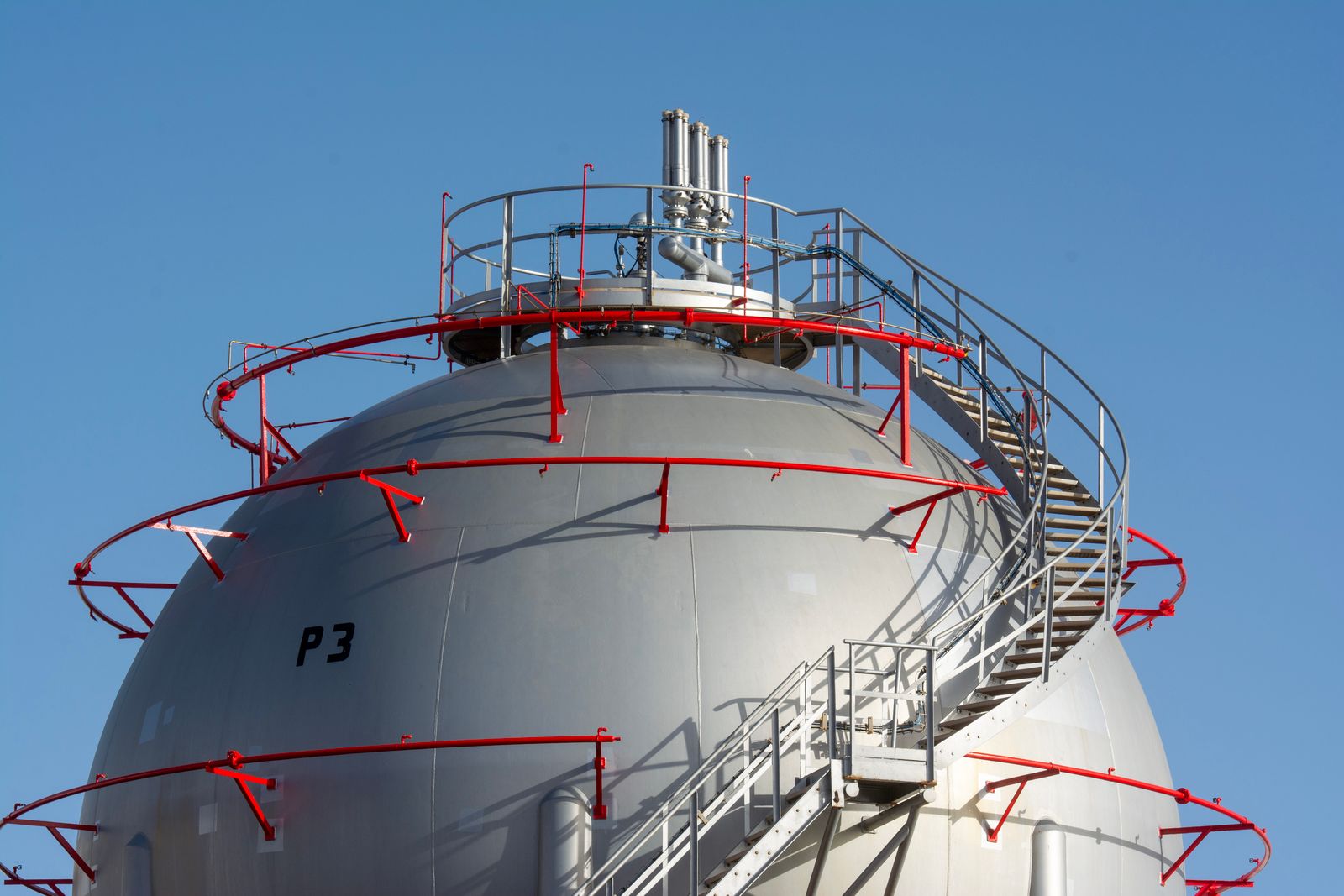 Instalaciones de gas y petróleo con tuberías y tanques en un entorno árido