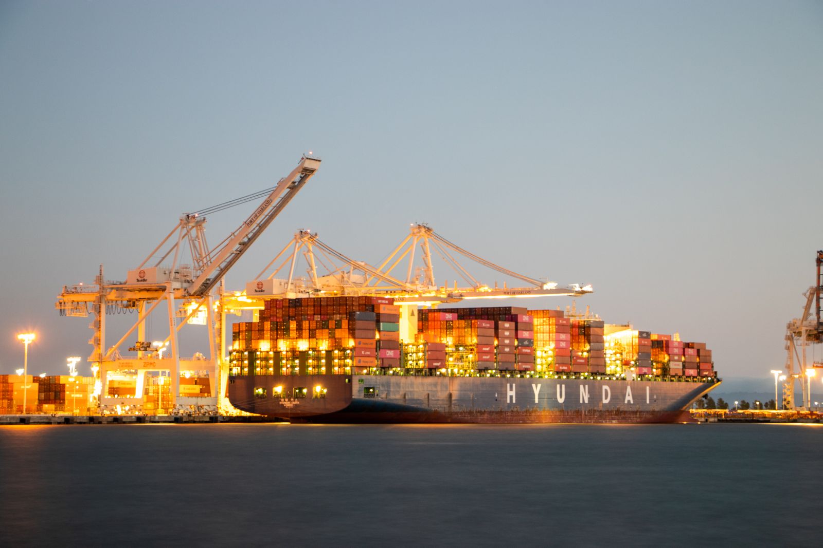 Puerto de contenedores con grúas y camiones representando la logística comercial en América Latina