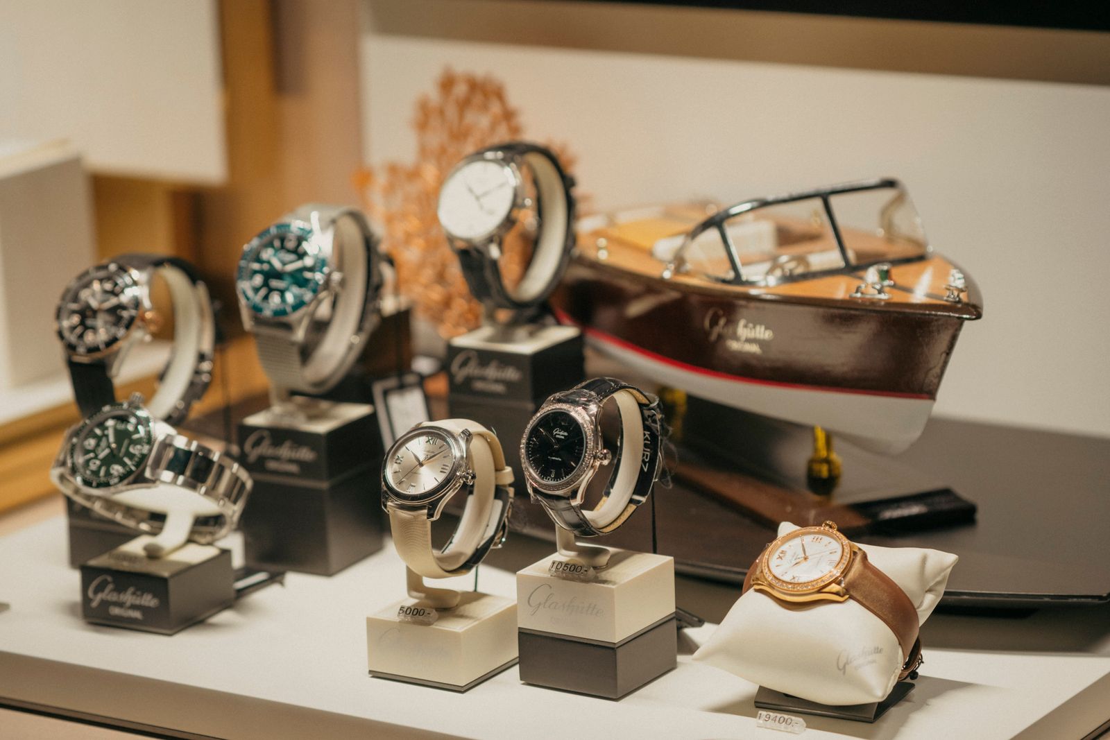 Relojes de pulsera de lujo exhibidos en una vitrina con iluminación cálida