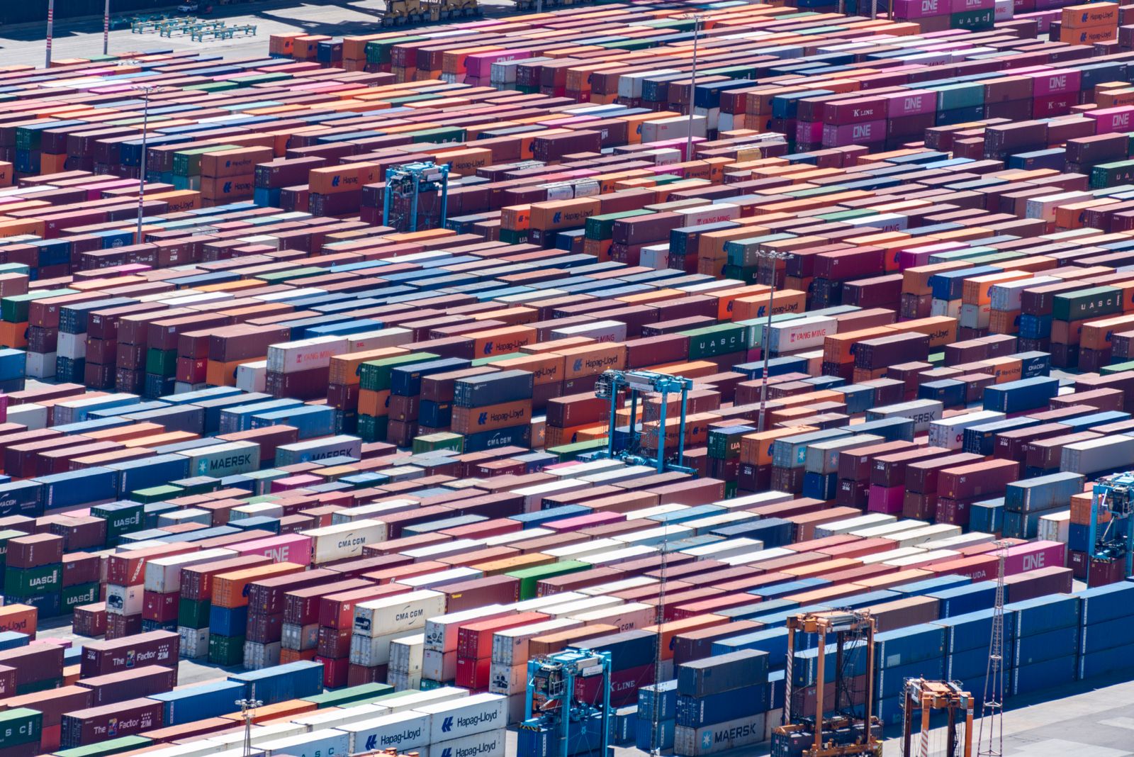 Puerto comercial con contenedores y grúas de carga