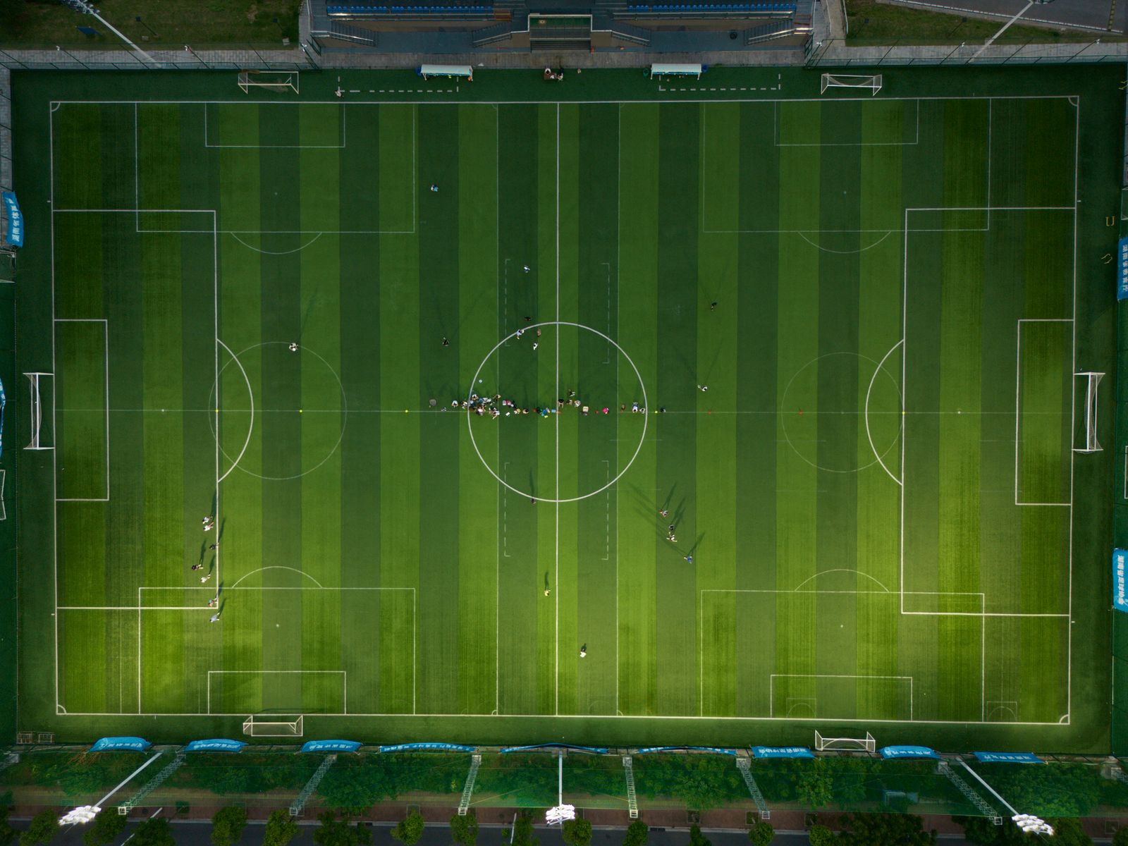 Estadio de fútbol iluminado con el campo de césped en primer plano