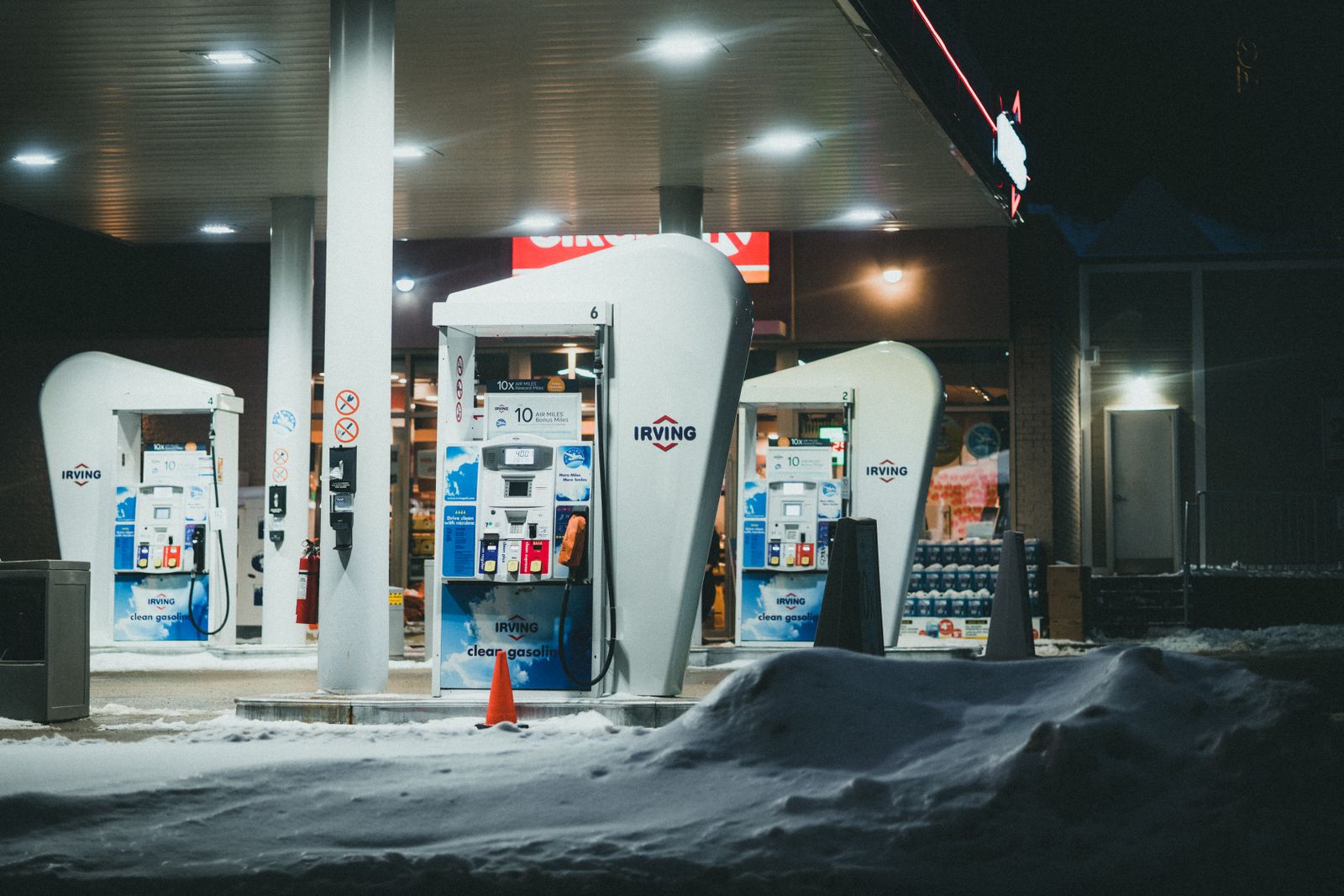 Estación de servicio moderna con surtidores de combustible y tienda de conveniencia al atardecer