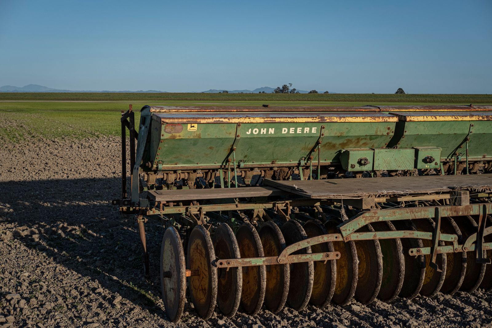 Manos sosteniendo semillas junto a frascos de conservación en un entorno agrícola
