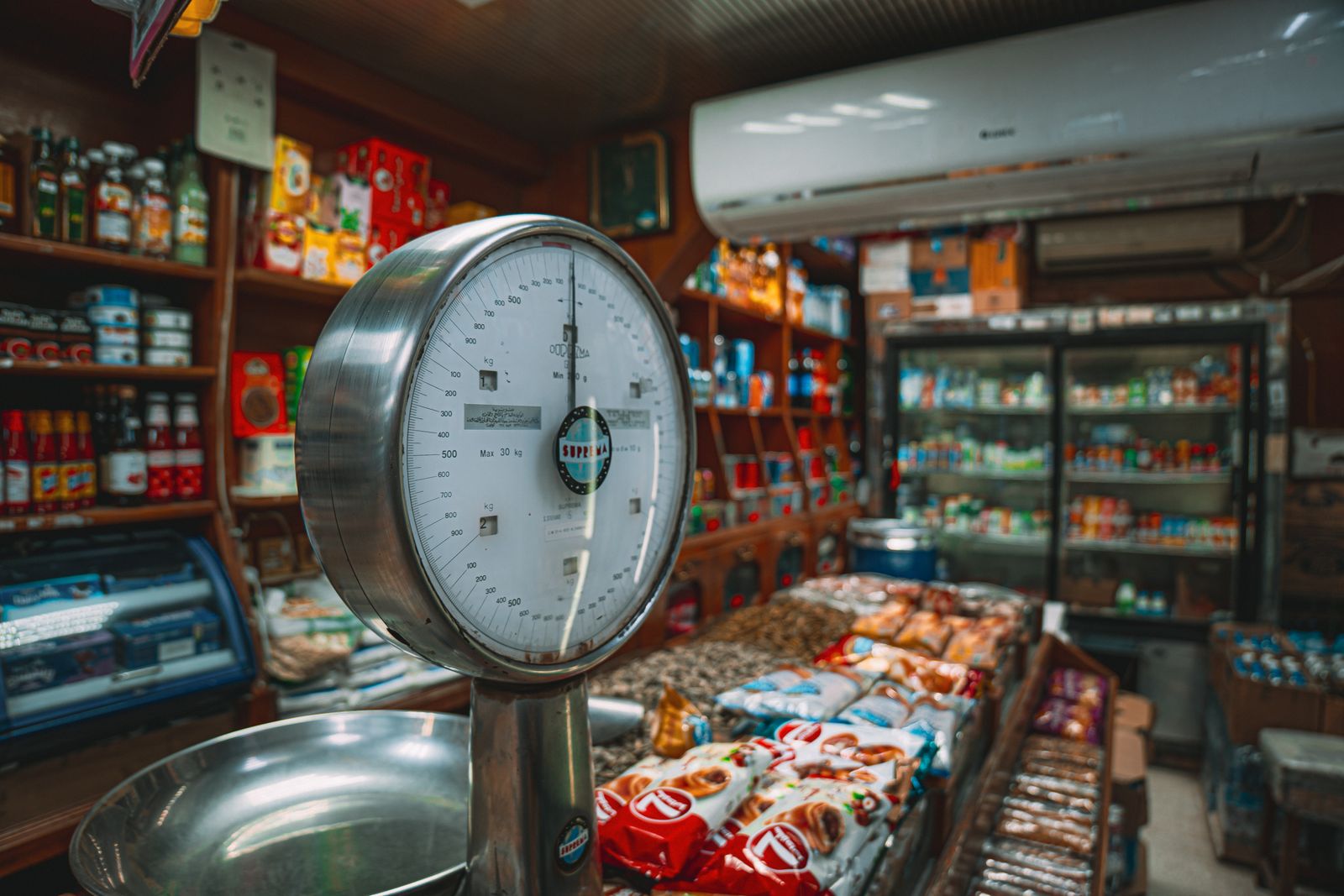 Interior de una tienda de conveniencia con estanterías y productos ordenados