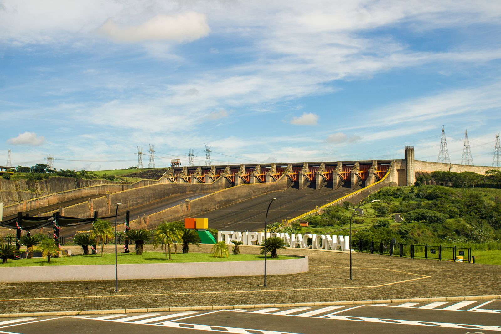 Infraestructura de energía con líneas de transmisión y paneles solares en un paisaje amplio.